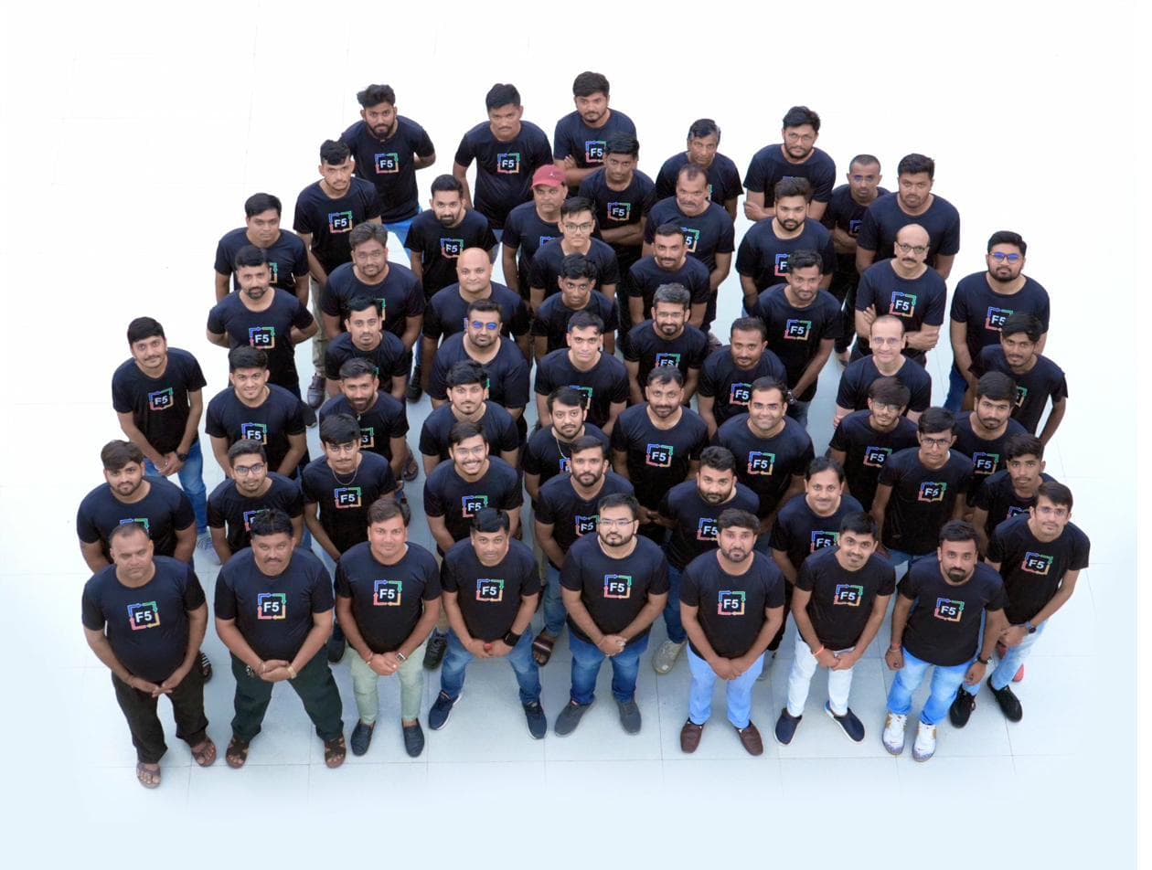 Around sixty F5 team members in branded shirts, photographed from above.